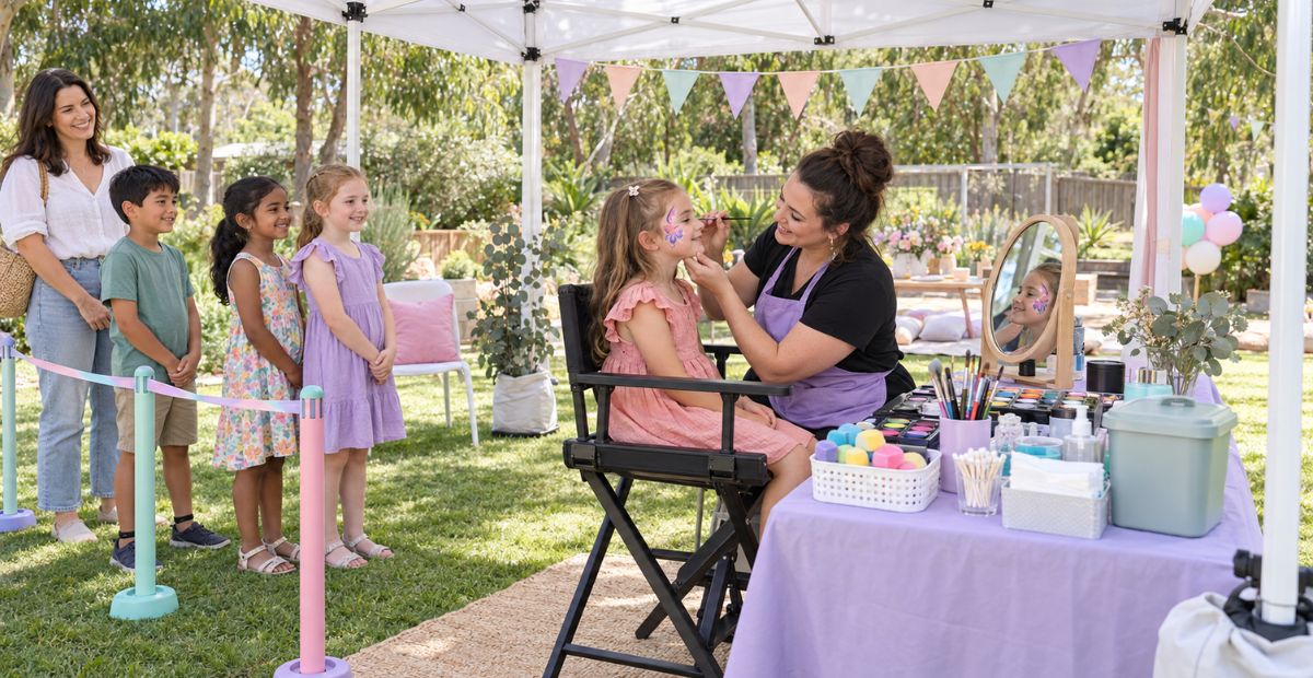Face painting station set up with a chair, mirror and shade, with a short orderly queue.