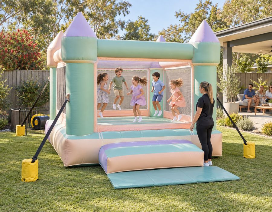 Jumping castle set up on flat grass in a backyard with clear space around it, children bou