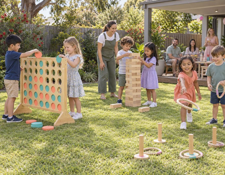 Giant garden games such as connect four, jenga and quoits set out on grass with children p